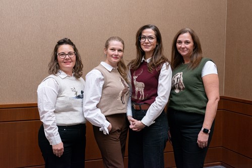 Four CancerCare Manitoba team members standing together wearing coordinated sweaters.