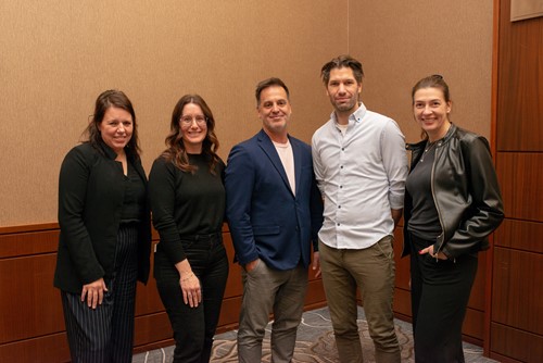 Five CHU de Québec – Université Laval team members standing together and smiling.